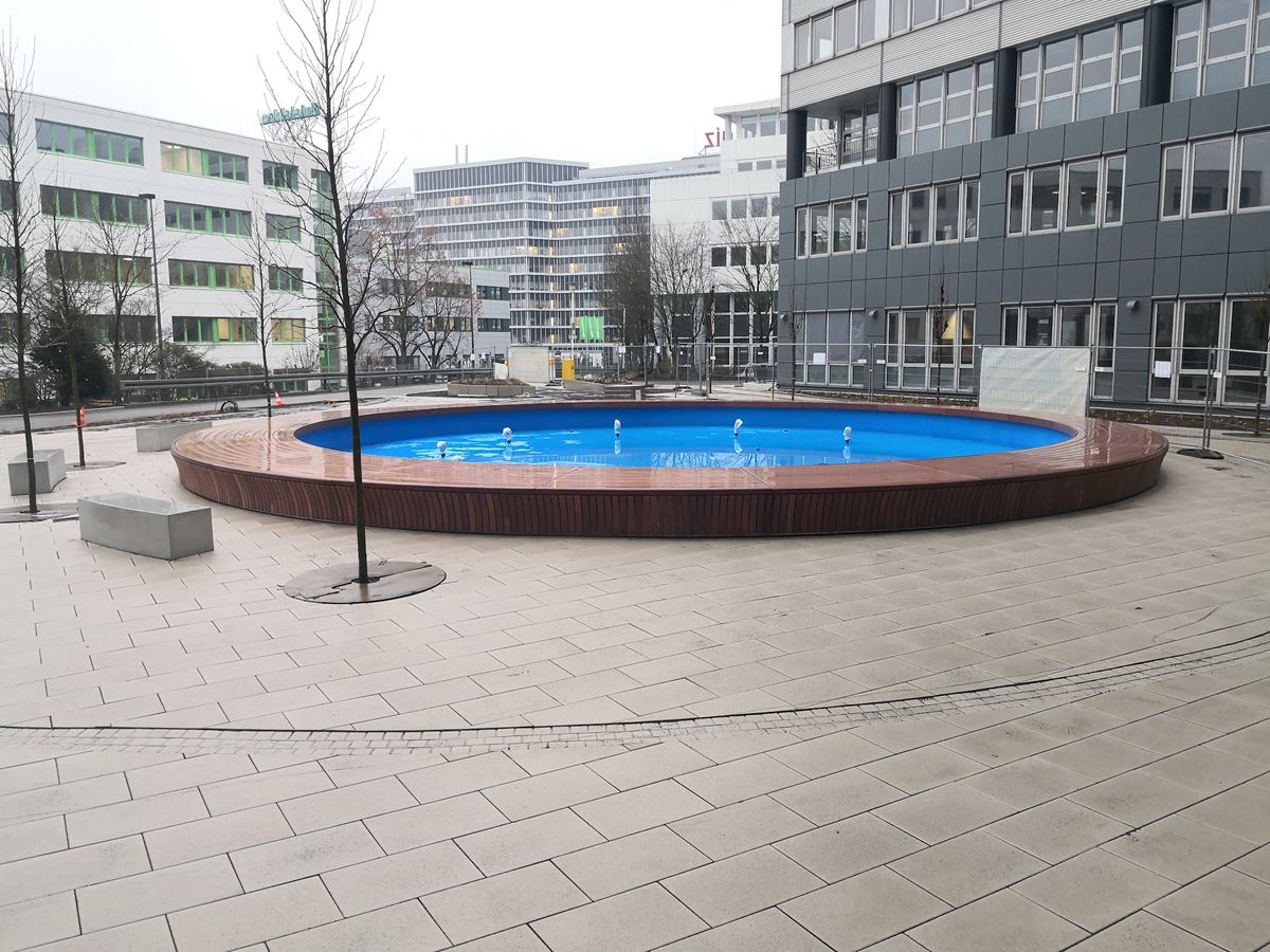 Geschwungene Sitzbank aus Holzlatten auf Stahlunterkonstruktion in der Werkstatt